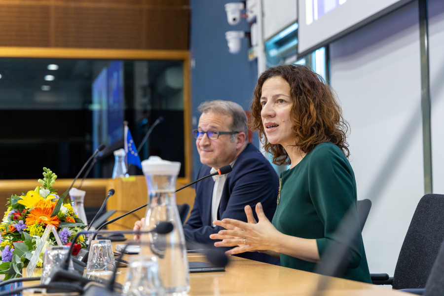 Man and woman speaking from a panel